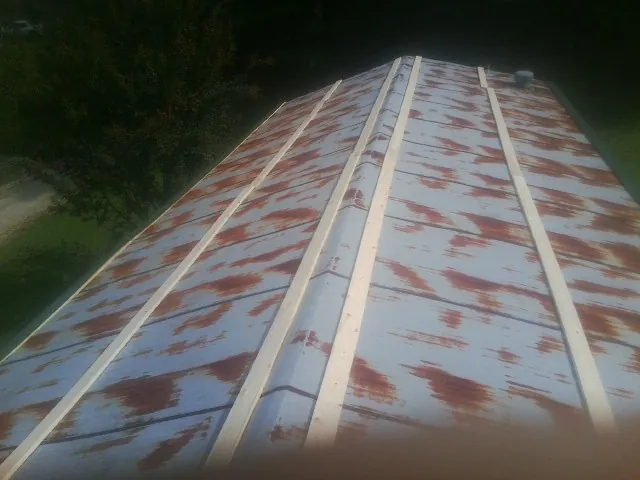 Rusted metal roof panels with new wood purlins before replacement — Storm Damage Roof Repair in Redvale by Roofing Brothers