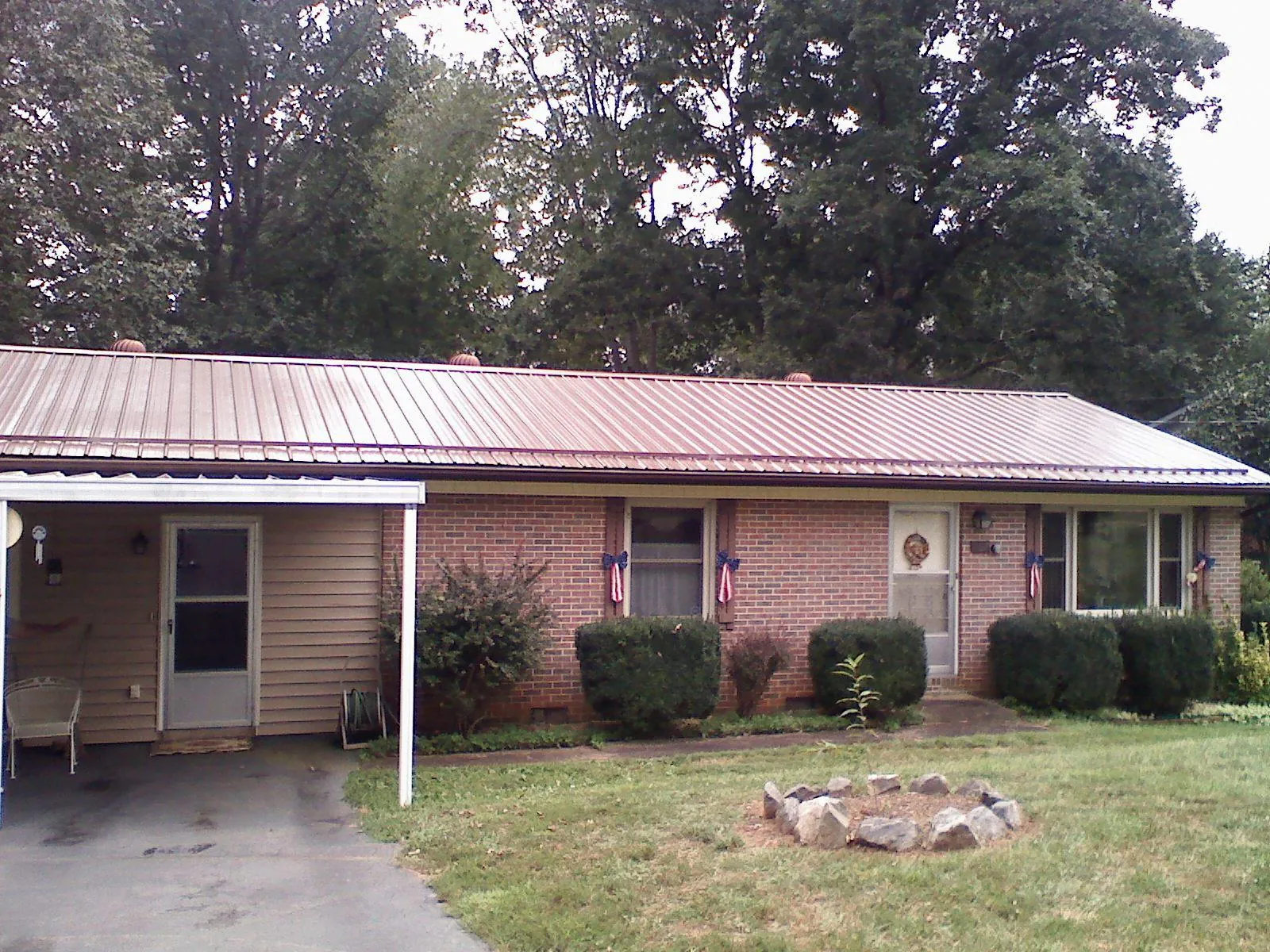 Bronze metal roof and carport on a brick ranch home — Roof Repair work by our crew in Redvale